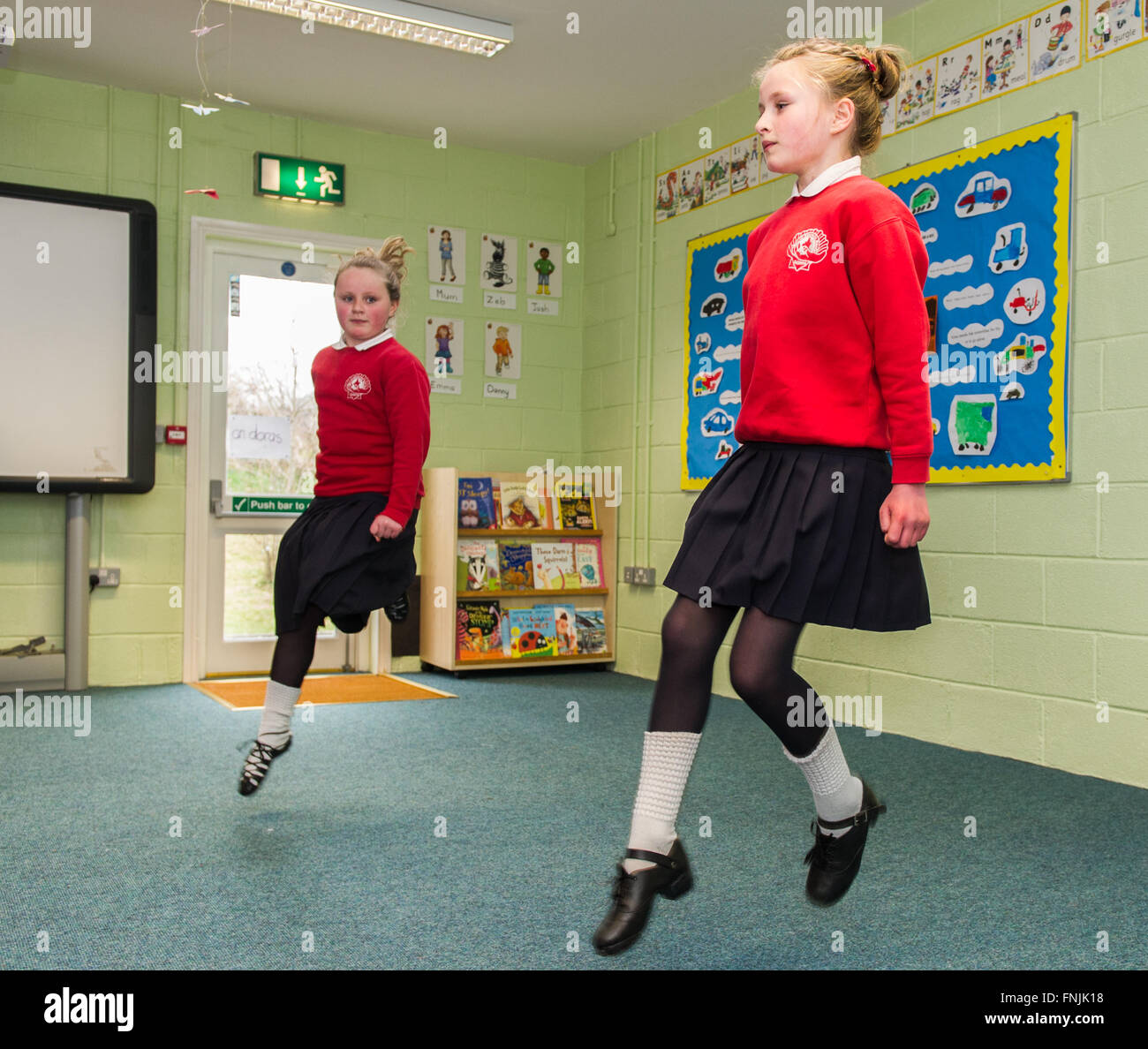 Durrus, Ireland. 15th March, 2016. Pupils and sisters Caitlin and Alicia Molloy perform an Irish dance for assembled parents at St James National School, Durrus, on Proclamation Day which was held to commemorate the events of 1916. Credit: Andy Gibson/Alamy Live News. Stock Photo
