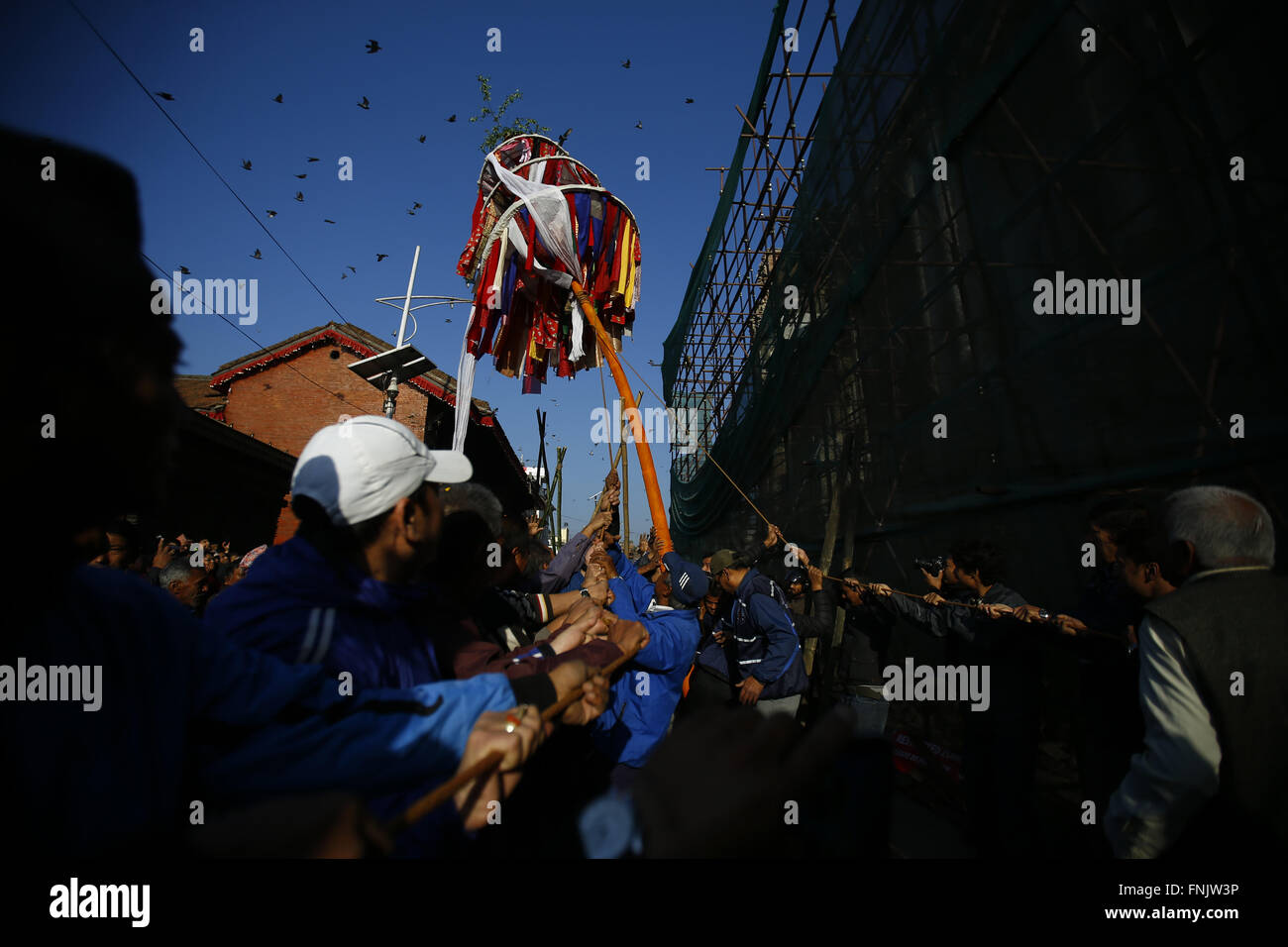 Kathmandu, Nepal. 16th Mar, 2016. Nepalese men raise a bamboo pole known as Chir to commence Holi festival in Basantapur Durbar Square, Kathmandu, Nepal on Wednesday, March 16, 2016. Hindu devotees set up a ceremonial pole to celebrate the first day of the festival. The Holi festival is also known as the festival of colors and is celebrated all over the country. © Skanda Gautam/ZUMA Wire/Alamy Live News Stock Photo