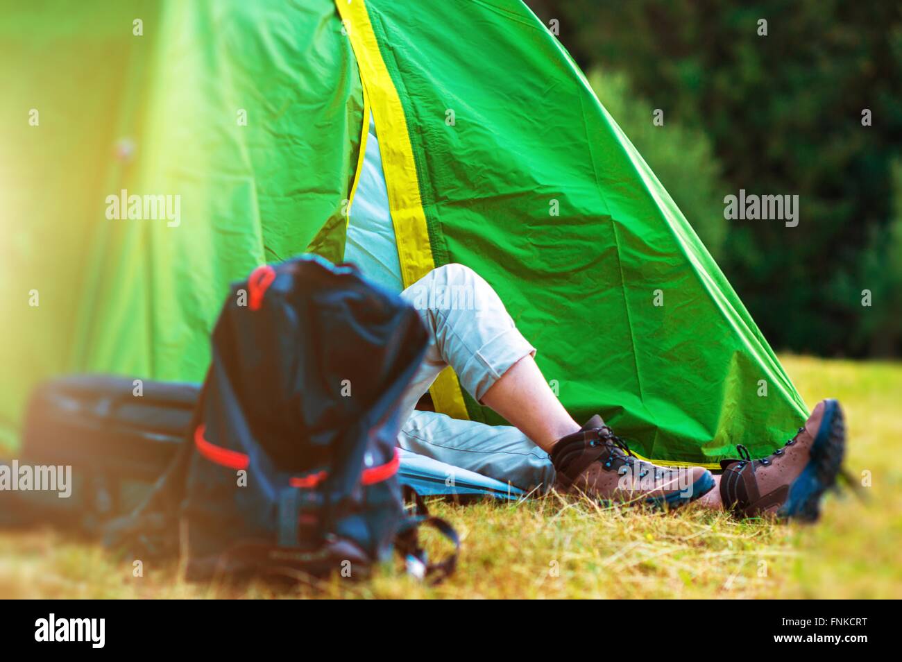 Wilderness Tent Camping. Hiker Resting in His Green Tent. Hiking and Camping Theme. Stock Photo