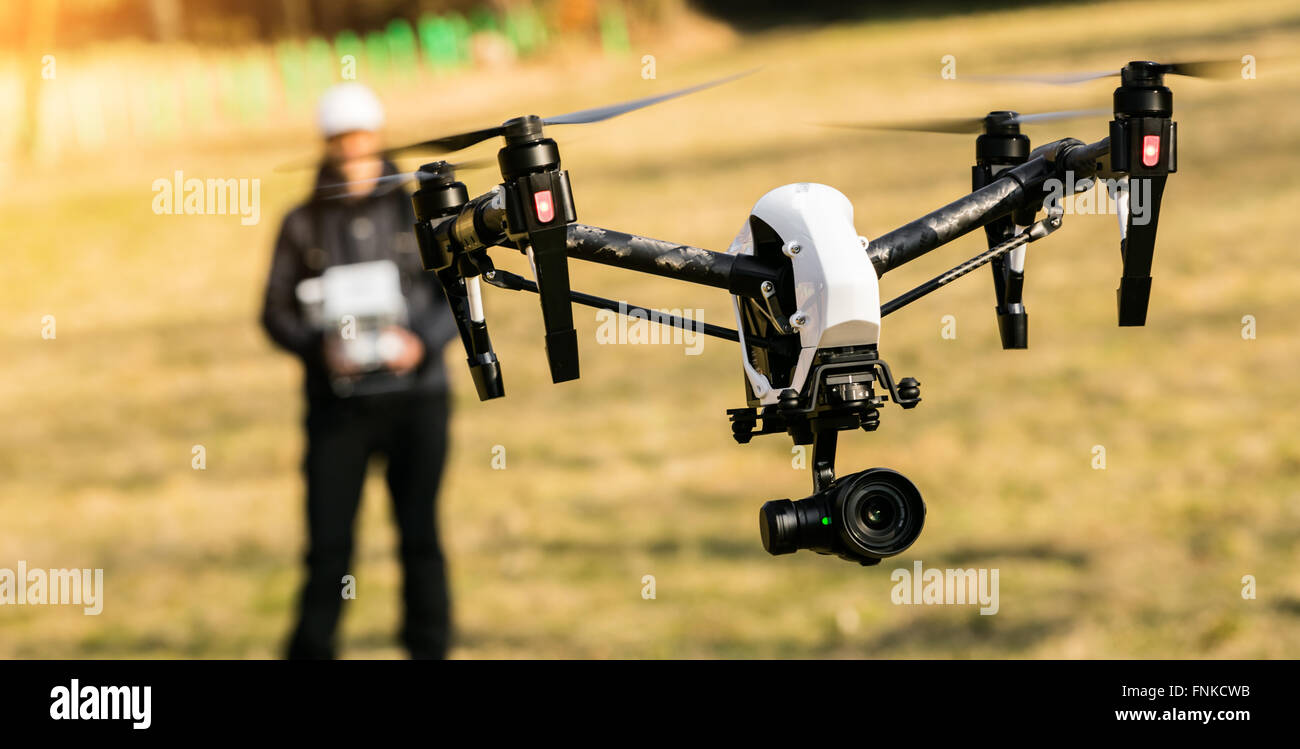 Man handling drone in nature, focused on drone Stock Photo