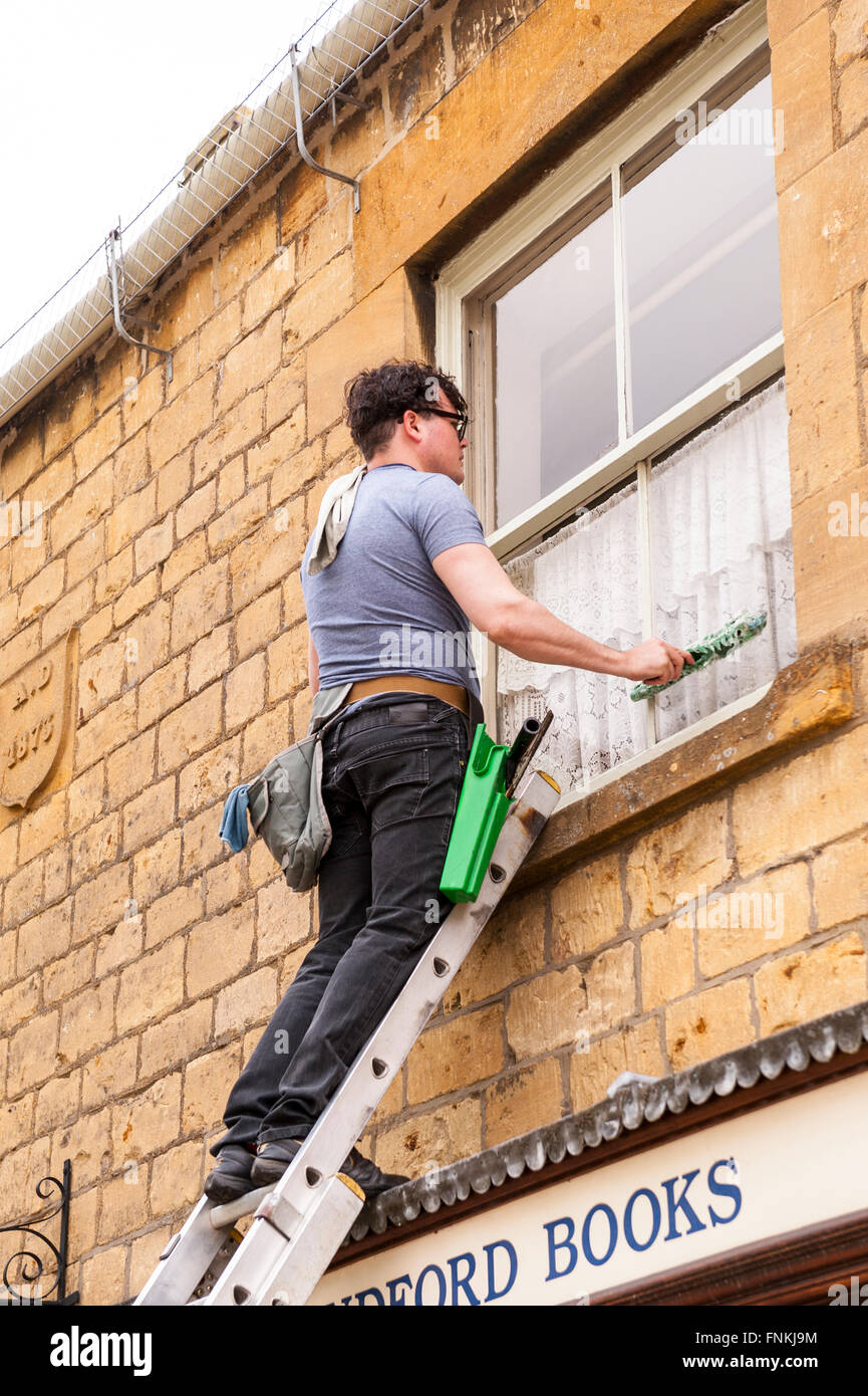 A window cleaner at work in Broadway ,  Worcestershire , England , Britain , Uk Stock Photo