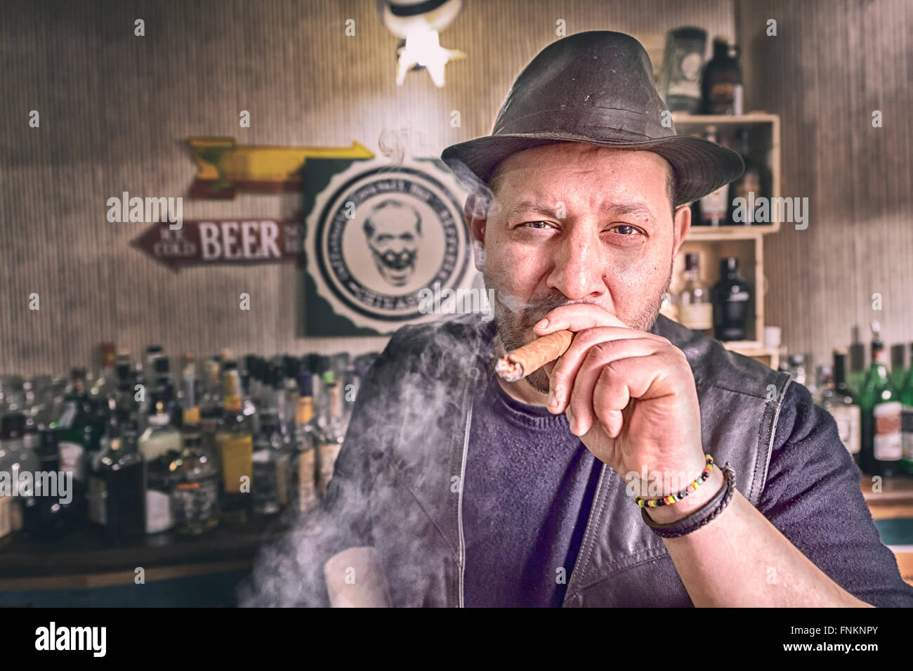 Man with cigar and hat in the pub, hi have black jacket Stock Photo