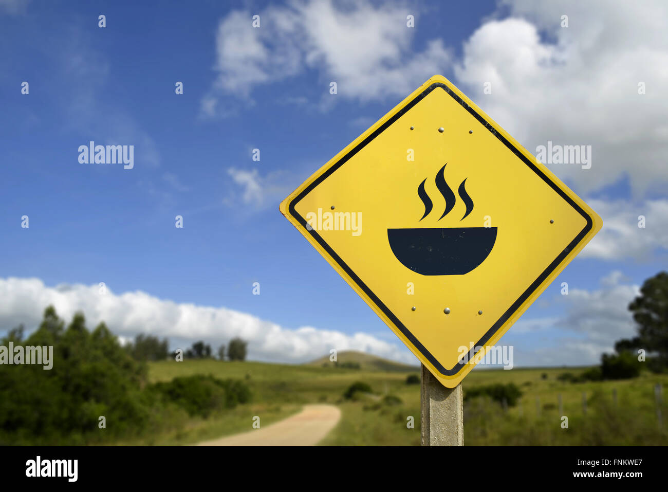 Eat natural food this way, organic home made meal concept. Road sign with hot dish gourmet icon in countryside landscape, Stock Photo