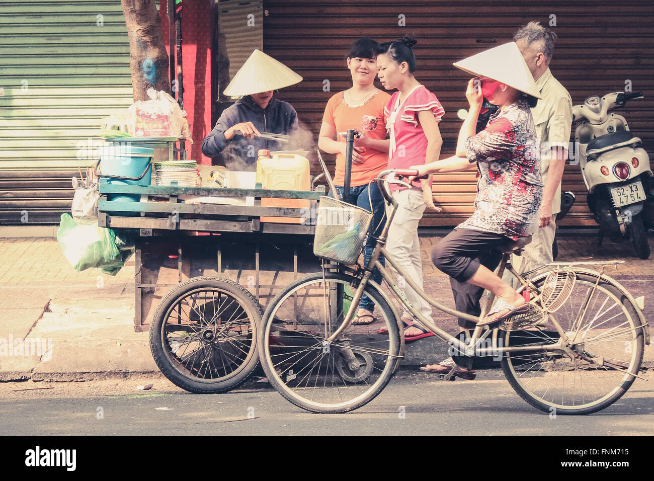 woman selling food on the street in sigon vietnam - noodle soup / pho - vietnamese breakfast Stock Photo