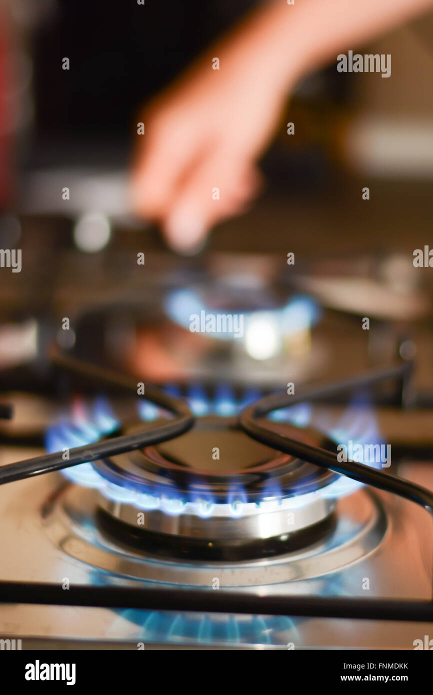 Woman turning on a gas stove Stock Photo Alamy