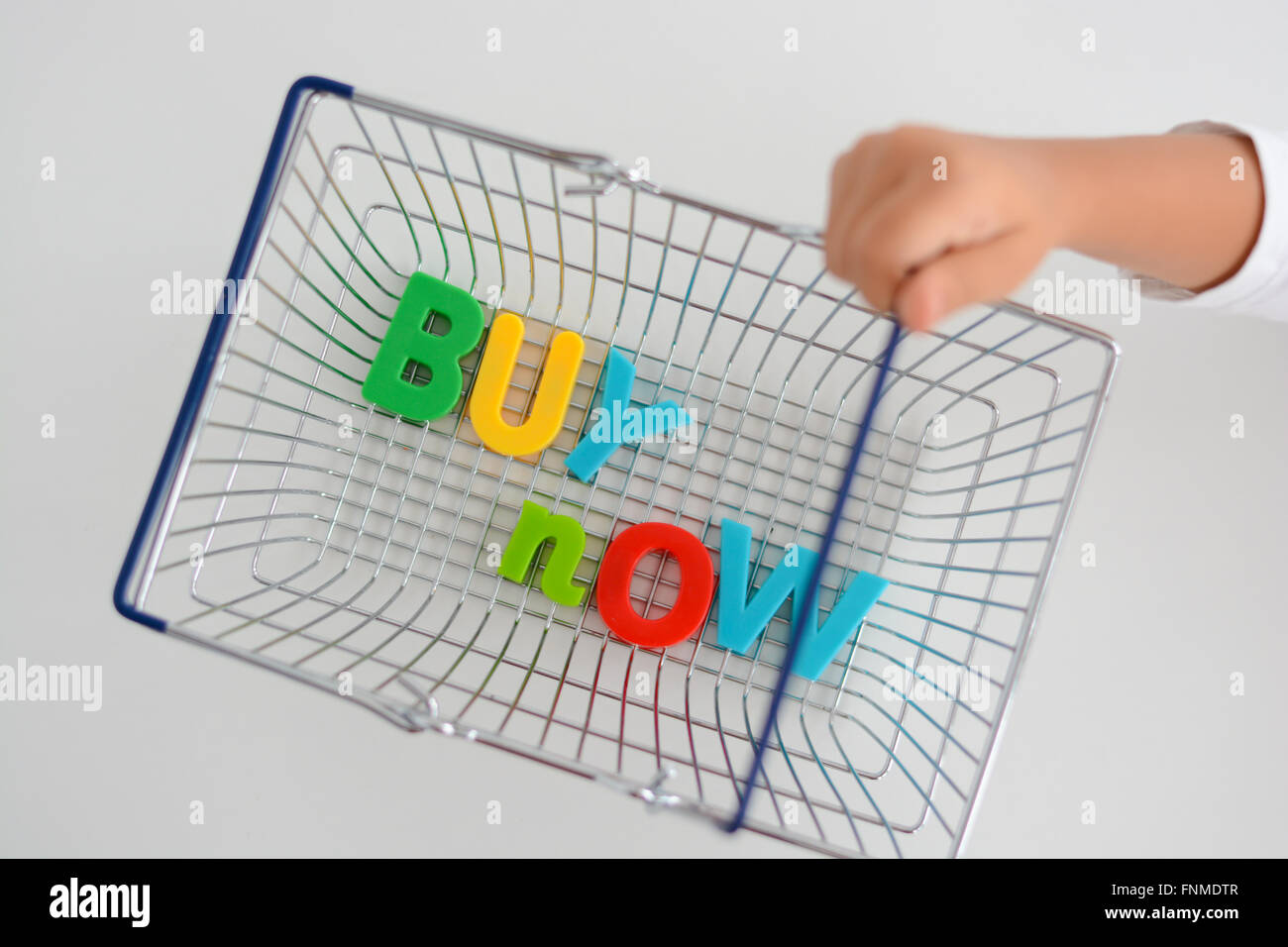 Buy now magnetic letters in a shopping basket Stock Photo