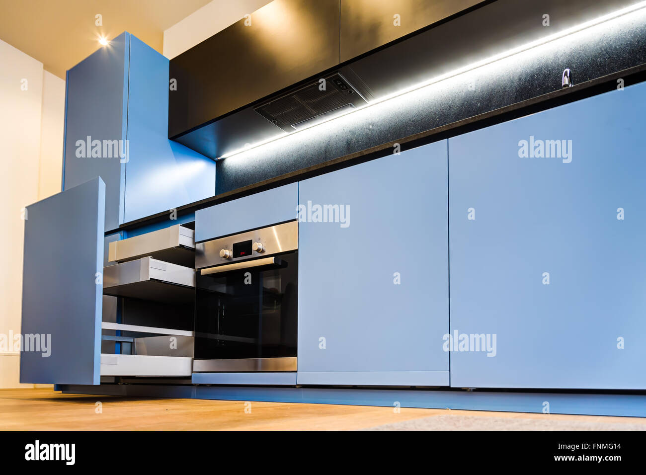Modern And Stylish Blue Kitchen Cabinets And Open Drawers Stock