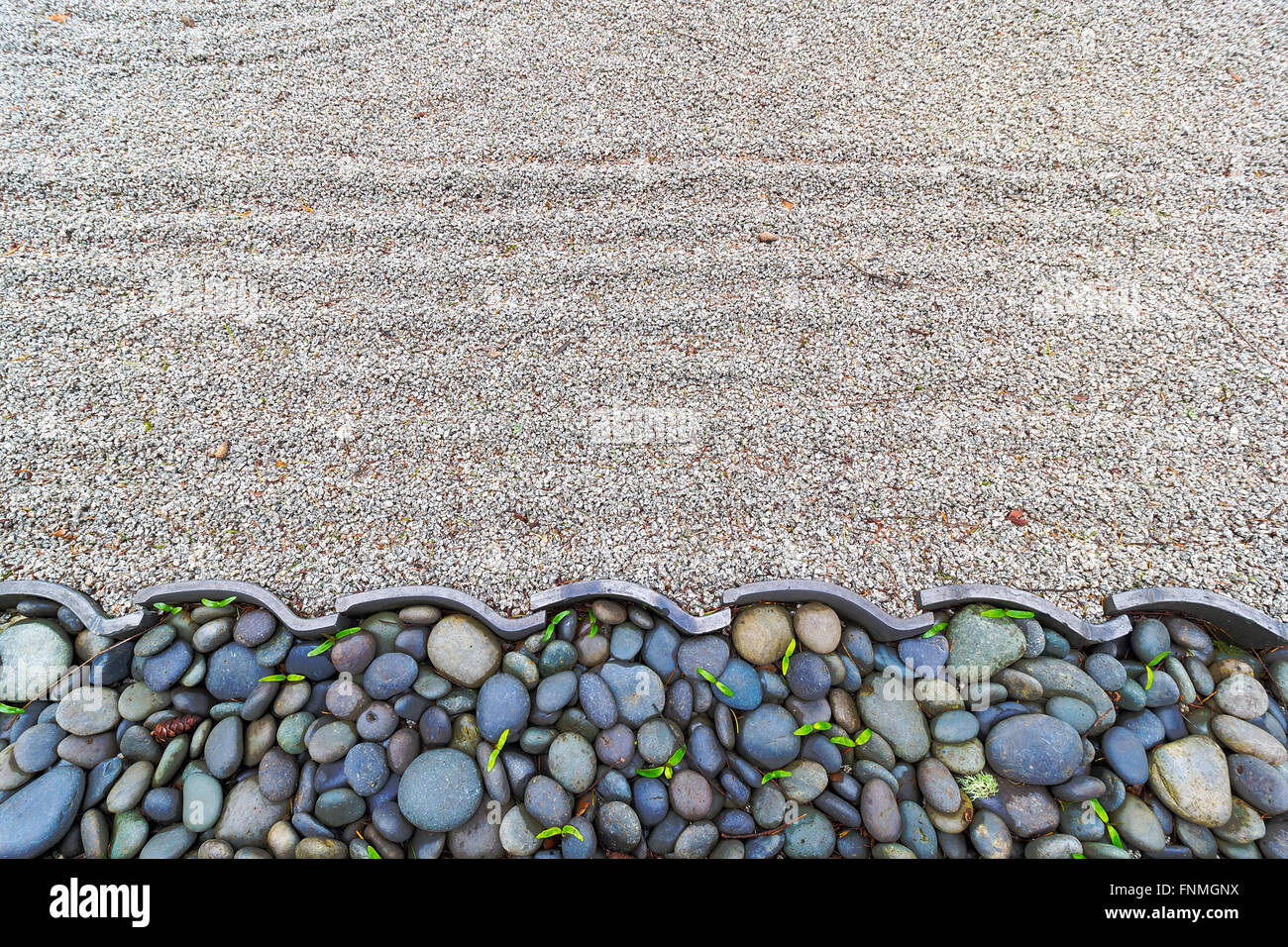 Sand Garden with Pebble Stones and Roof Tiles Border at Japanese Garden Stock Photo