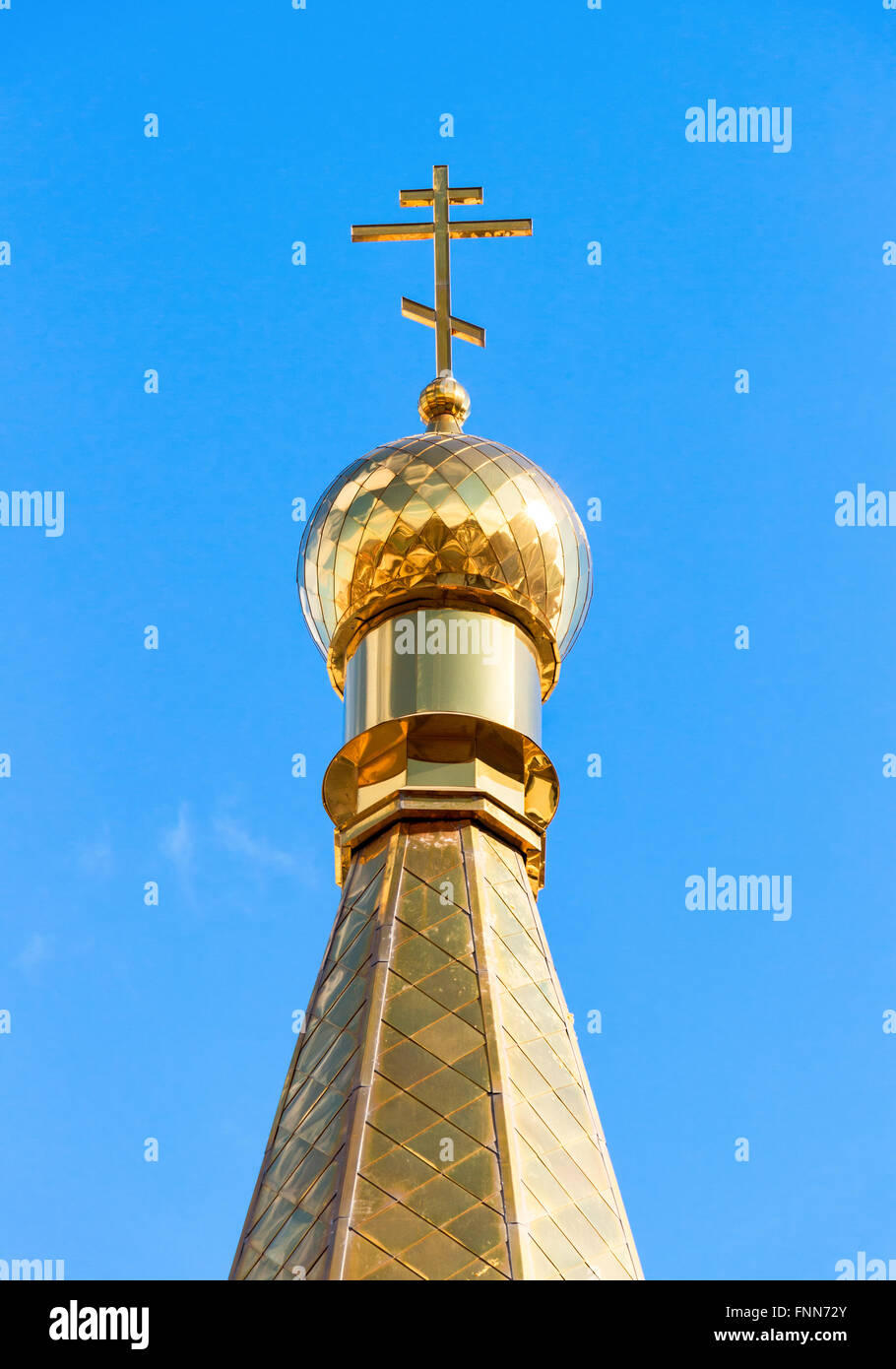 Golden dome of Russian orthodox church with cross against blue sky ...