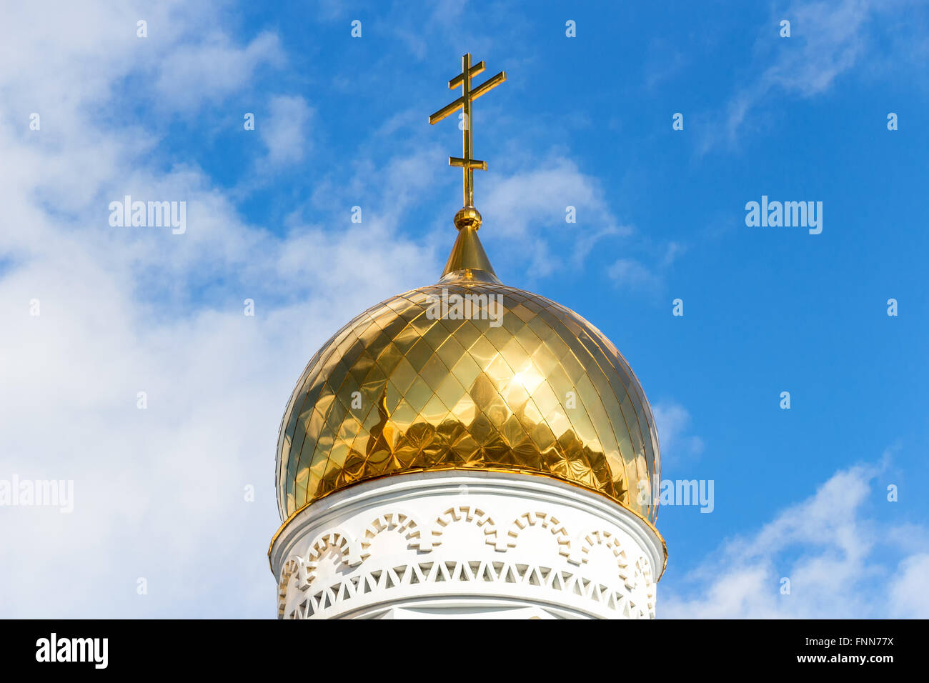 Golden dome of Russian orthodox church with cross against blue sky ...