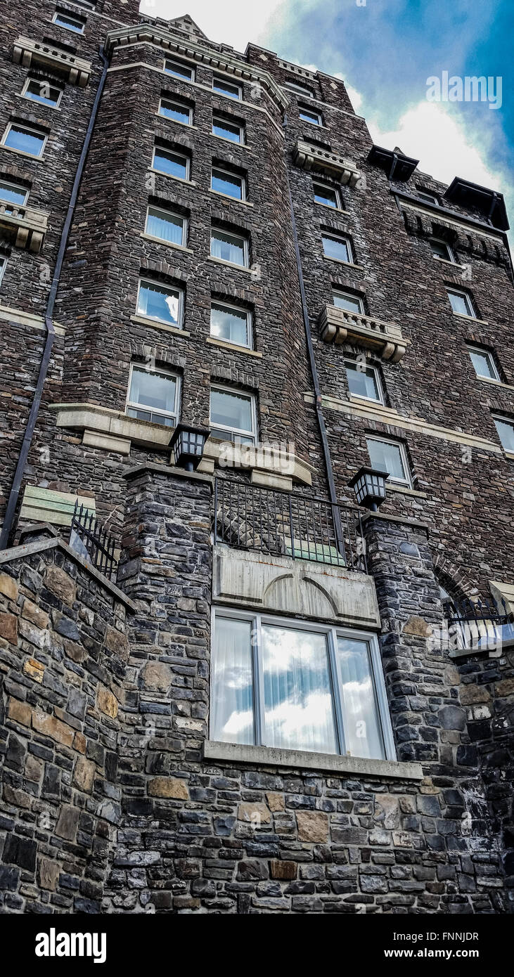 Bug's eye view of the stones and bricks of the Banff Springs Hotel leading up to a blue sky Stock Photo