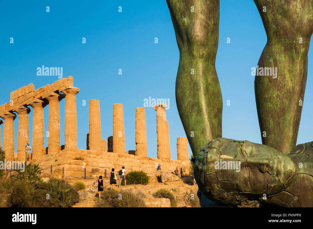 Gambe Alate -Winged legs- bronze statue of Igor Mitoraj, in the background the Temple of Juno Lacinia. Valley of the Temples Stock Photo