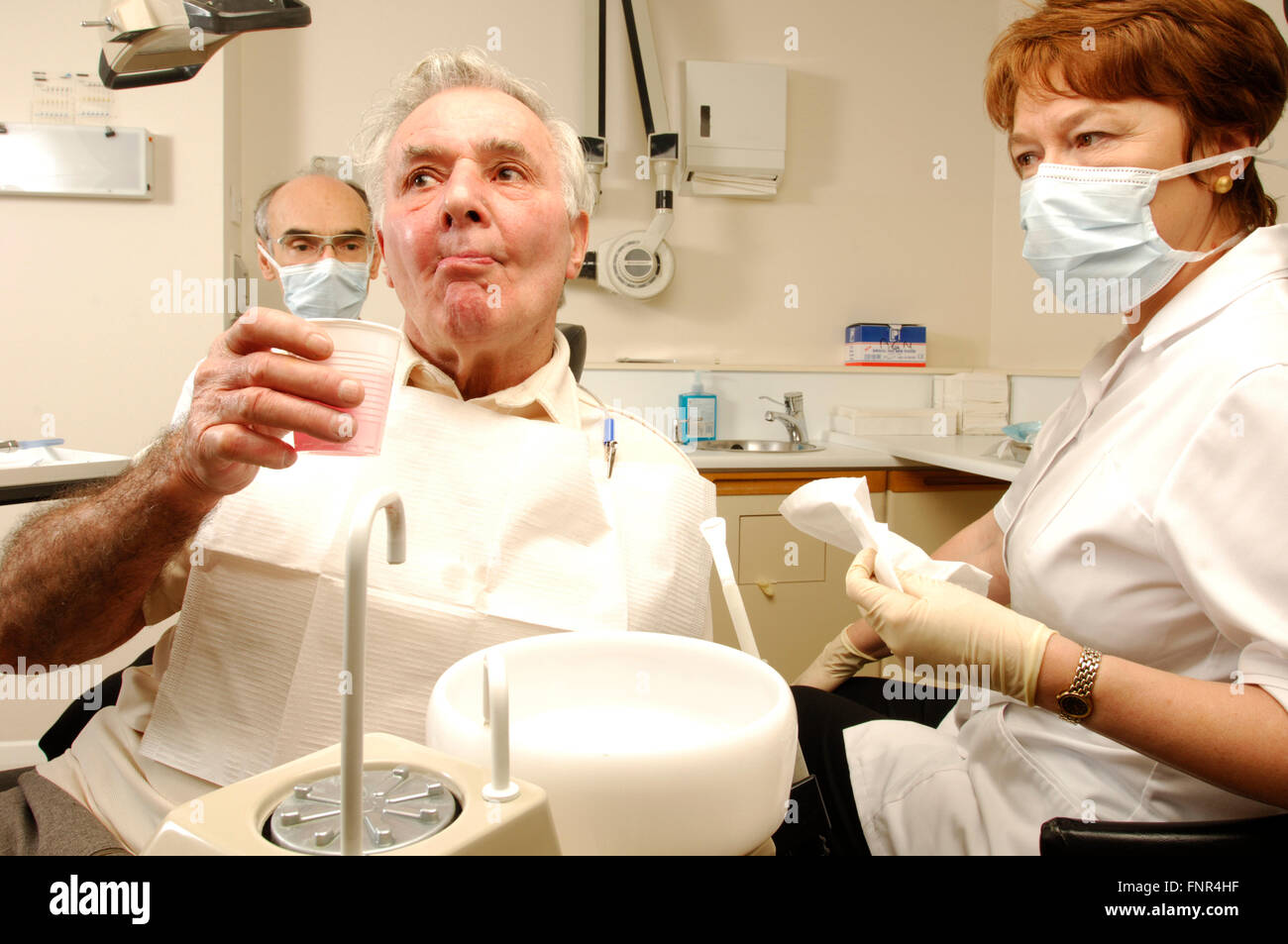 An elderly man rinses with antimicrobial mouth wash after dental