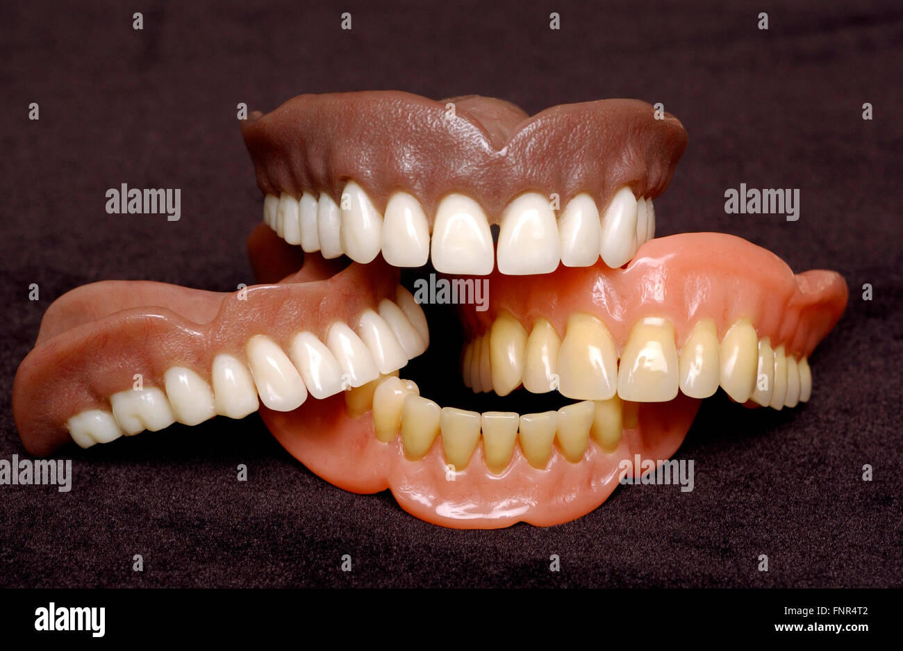 Two sets of full dentures. Dentures or false teeth are made from an acrylic base on which acrylic or ceramic teeth are mounted. Stock Photo