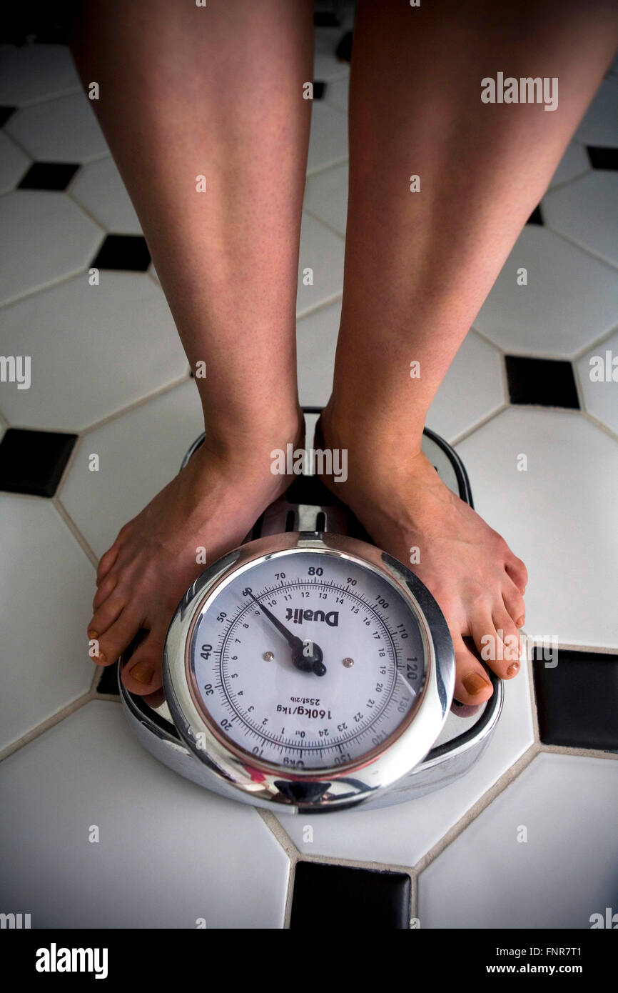 Woman weighing herself. Stock Photo