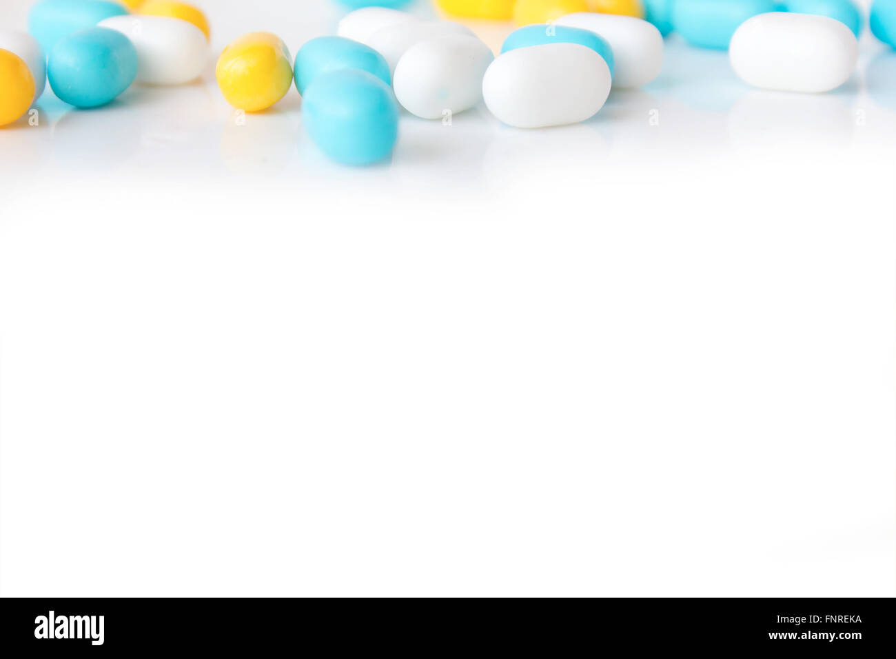 Blue yellow and white pills on white background Stock Photo