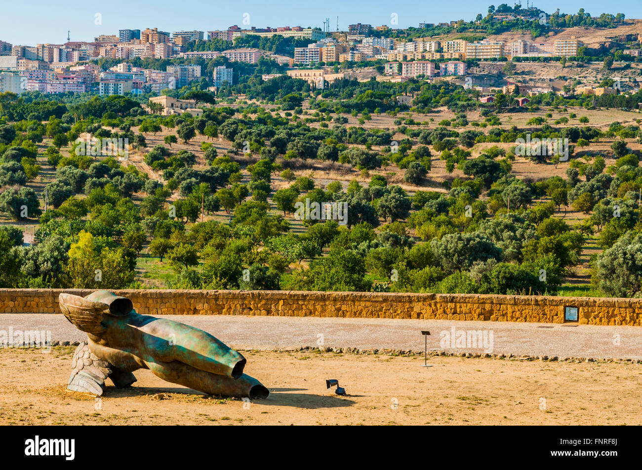 Fallen Icarus -Ikaro Caduto- bronze statue of Igor Mitoraj, In the background the city of Agrigento. Valley of the Temples. Stock Photo
