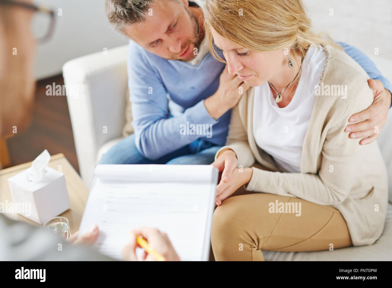 Crying woman visiting psychologist with her husband Stock Photo