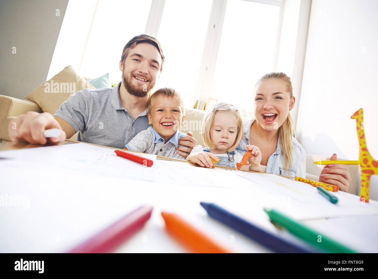 Portrait of happy young family sitting on sofa Stock Photo