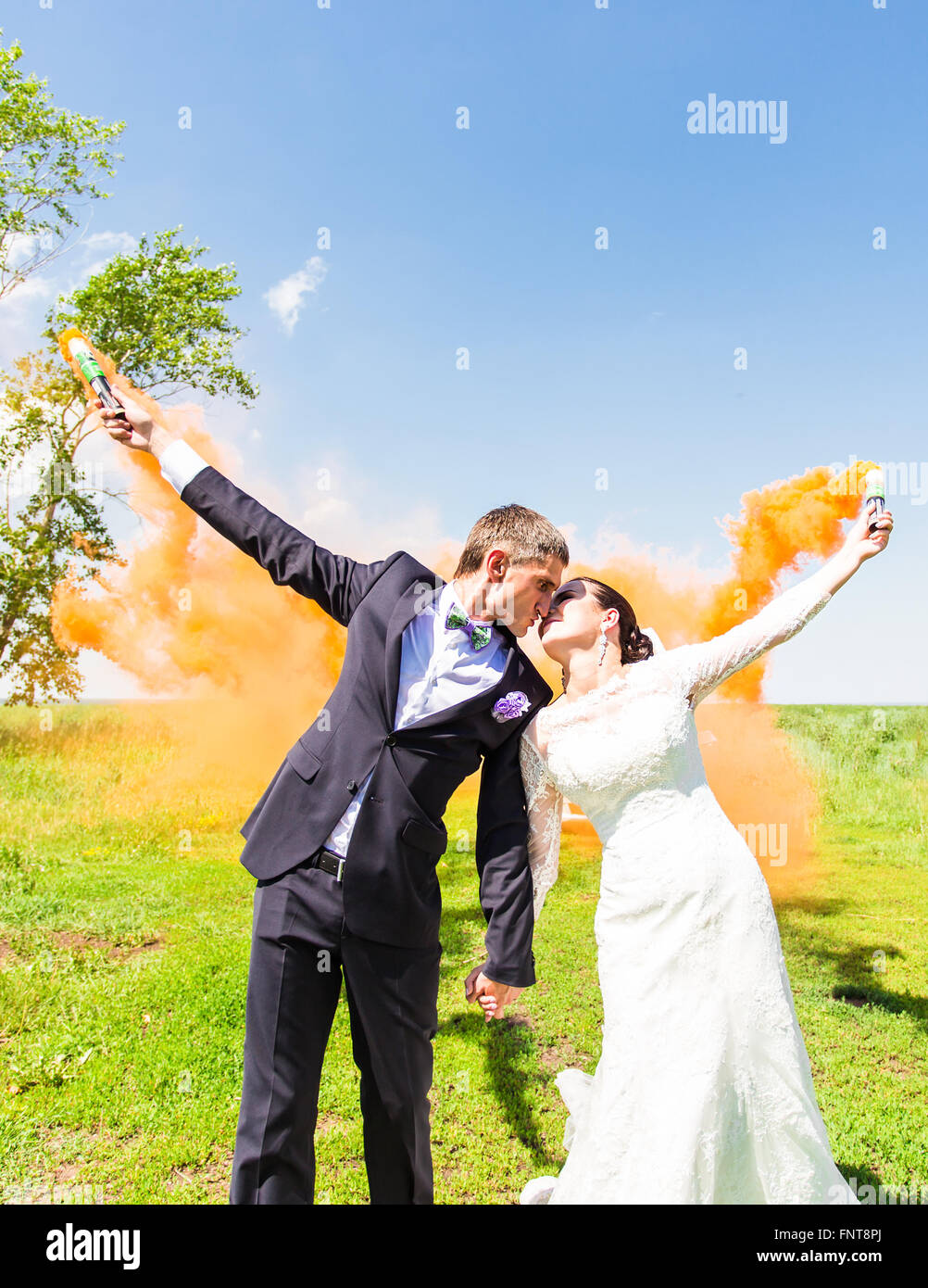 Wedding couple kissing with color smoke in the summer park Stock Photo ...