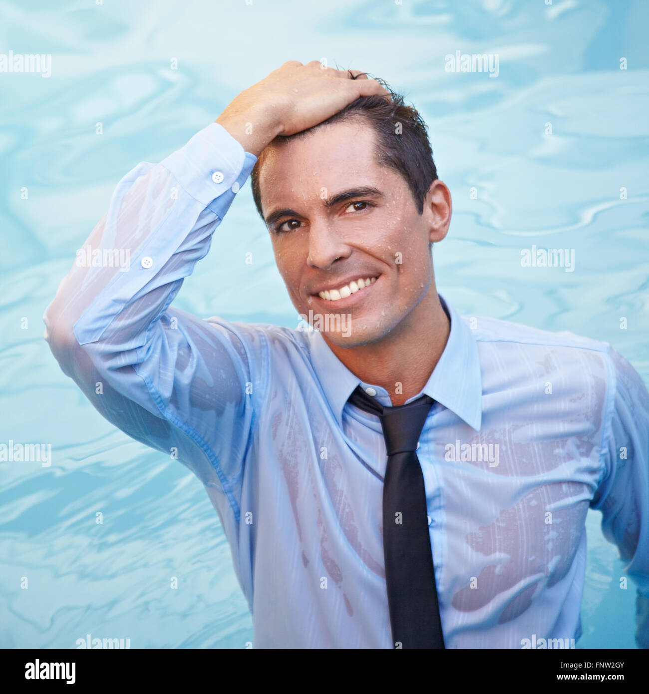 Smiling business man with wet clothes in blue water Stock Photo Alamy
