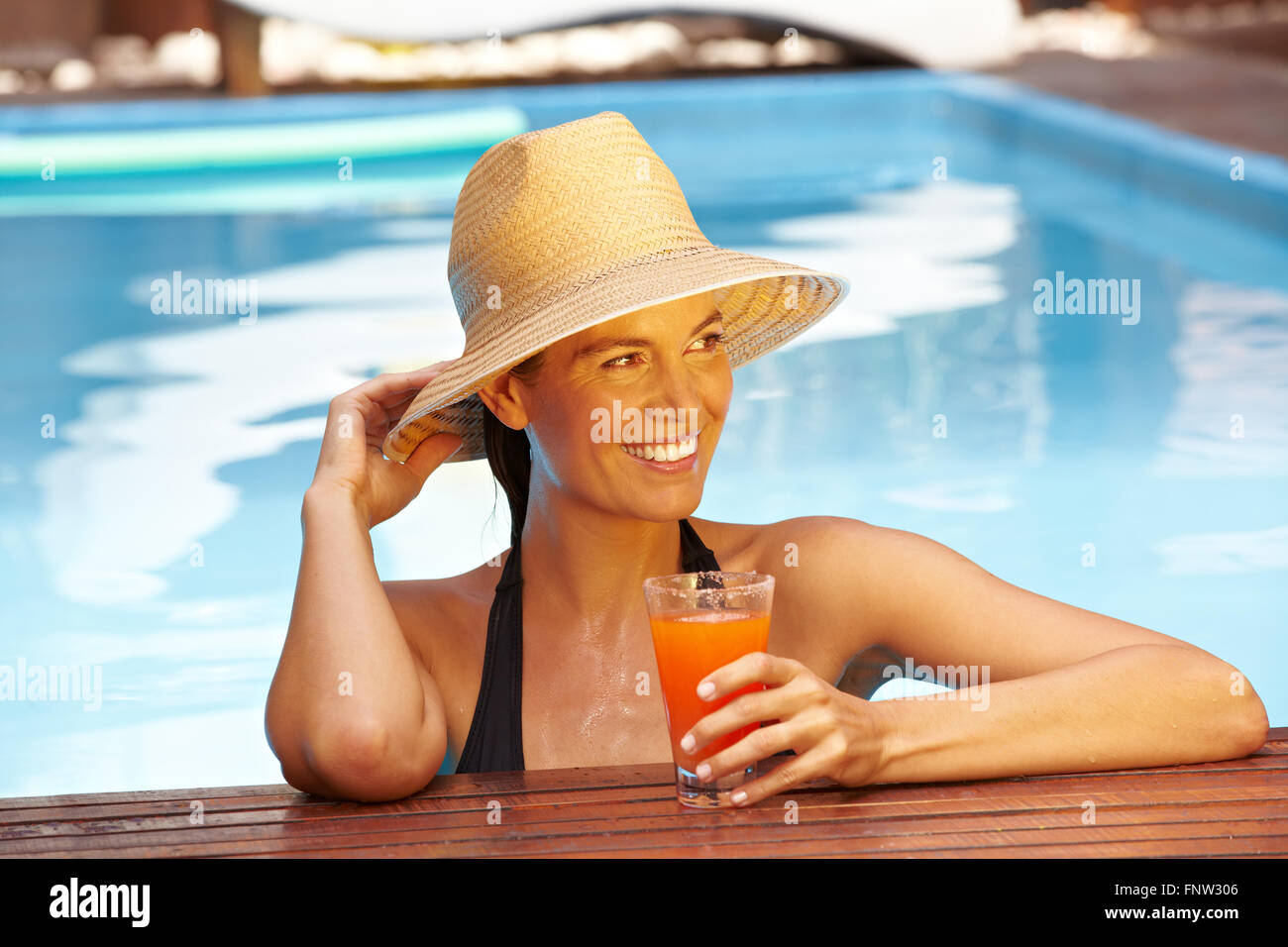 Happy smiling woman with straw hat in swimming pool Stock Photo - Alamy