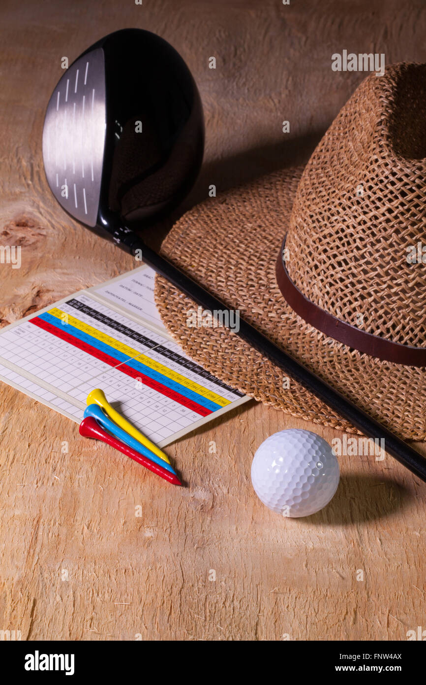 Siesta - straw hat and golf driver on a wooden table Stock Photo