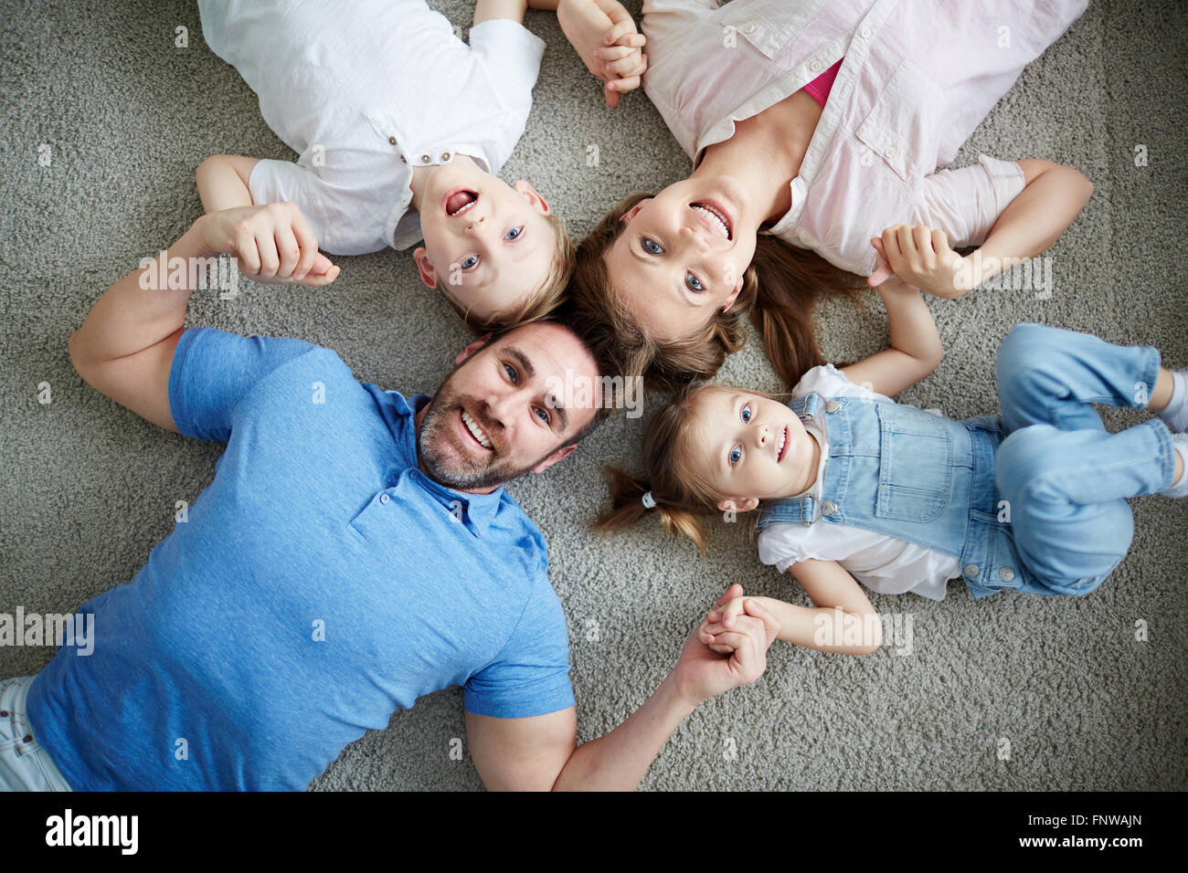 Portrait of happy family lying on floor Stock Photo - Alamy