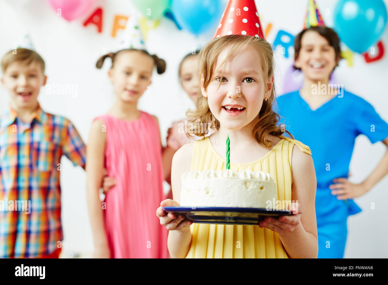 Little girl holding birthday cake and smiling Stock Photo - Alamy