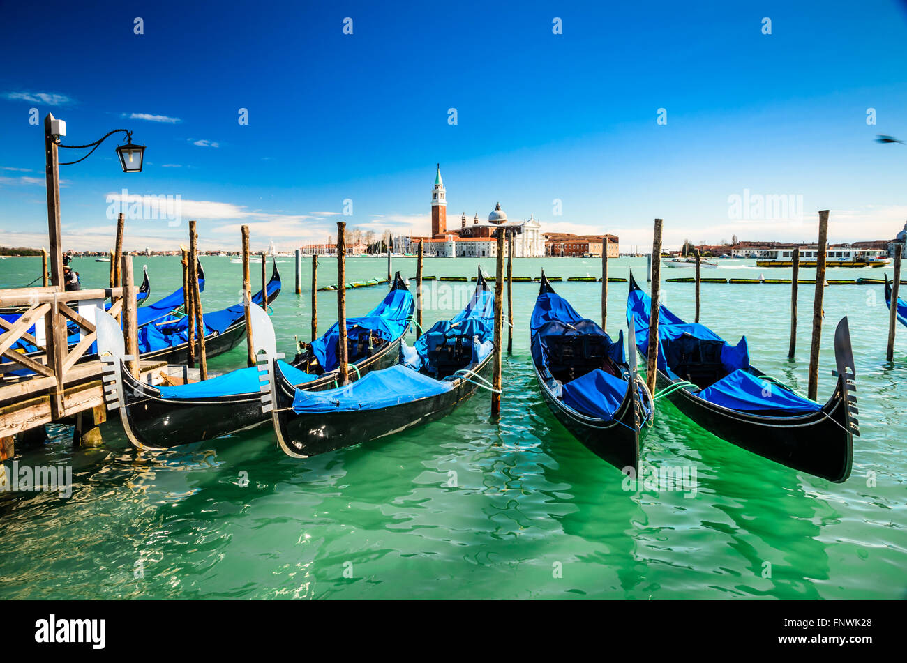 Venice Italy. Gondolas moored by San Marco Square with San Giorgio di Maggiore church in the background - Venezia, Europe. Stock Photo