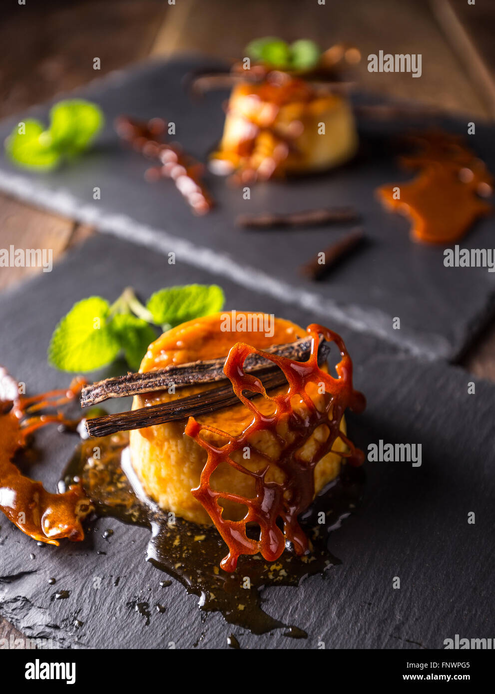 Caramel custard served on black slate Stock Photo