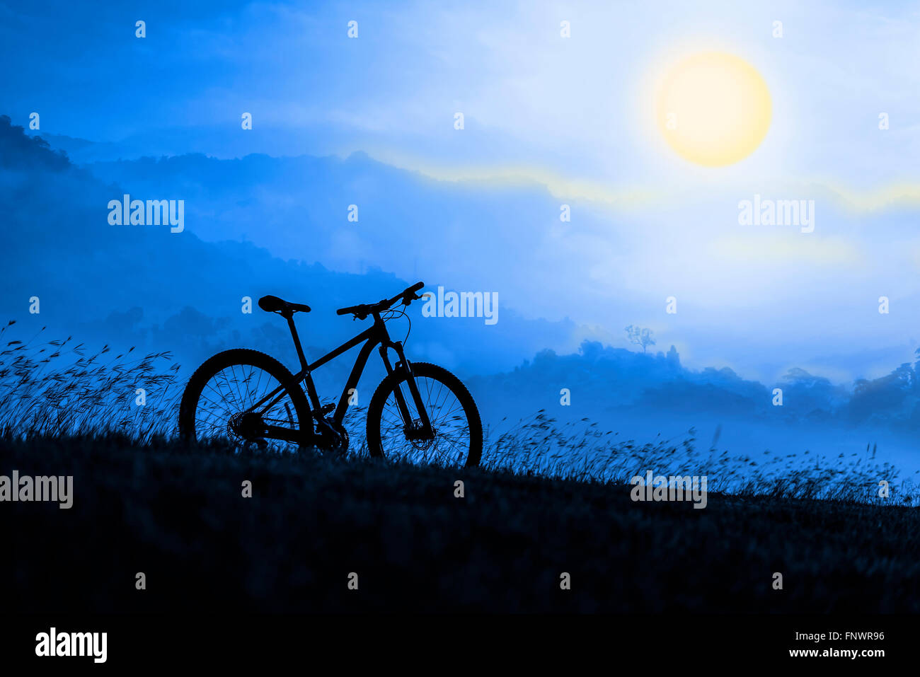 Silhouette Mountain bike on beautiful landscape, Silhouette Bicycle sunset on beautiful landscape mountain and foggy moon Stock Photo