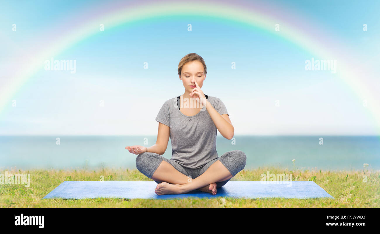 woman making yoga meditation in lotus pose on mat Stock Photo - Alamy
