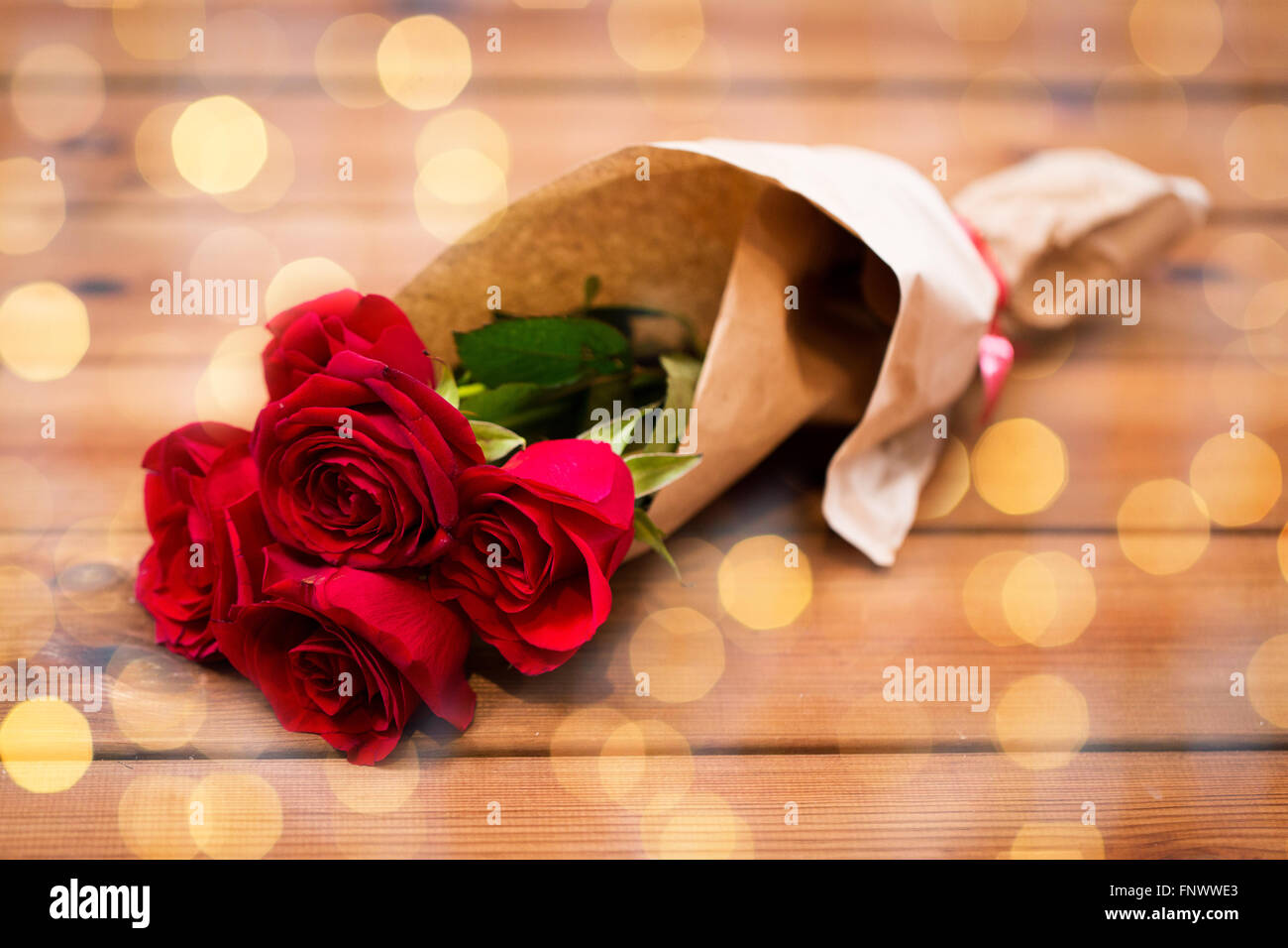close up of red roses bunch wrapped into paper Stock Photo - Alamy