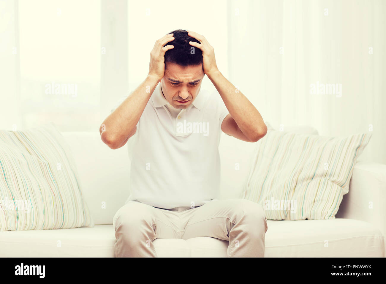 unhappy man suffering from head ache at home Stock Photo - Alamy