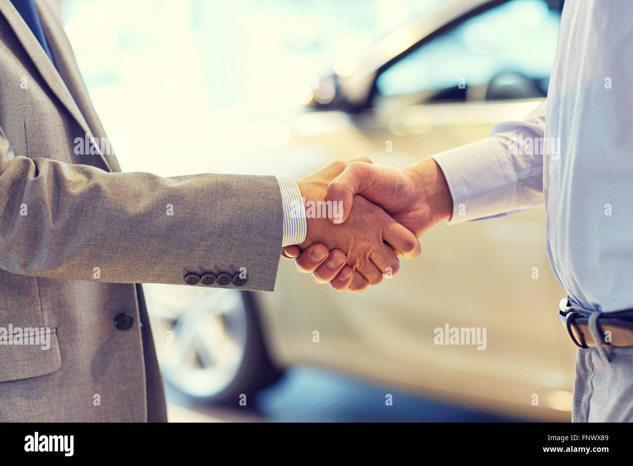 close up of male handshake in auto show or salon Stock Photo