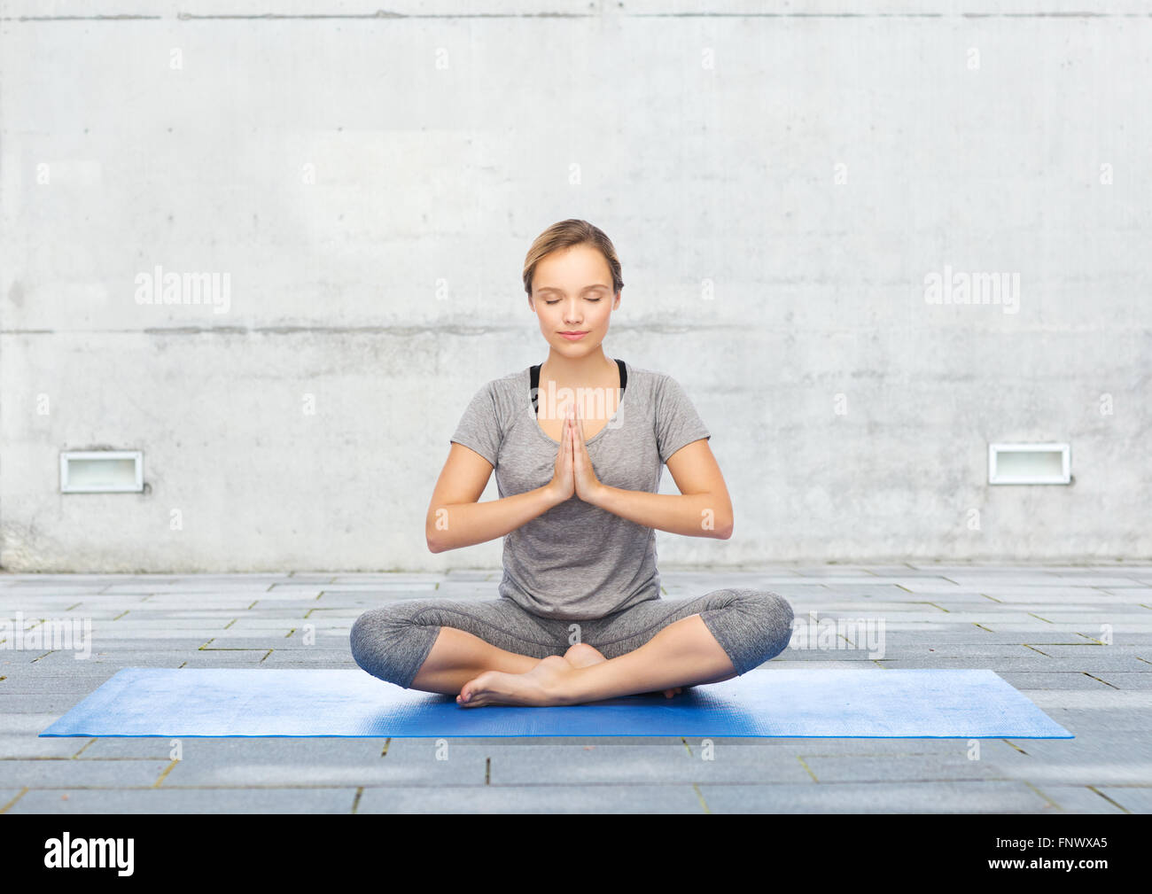 woman making yoga meditation in lotus pose on mat Stock Photo - Alamy
