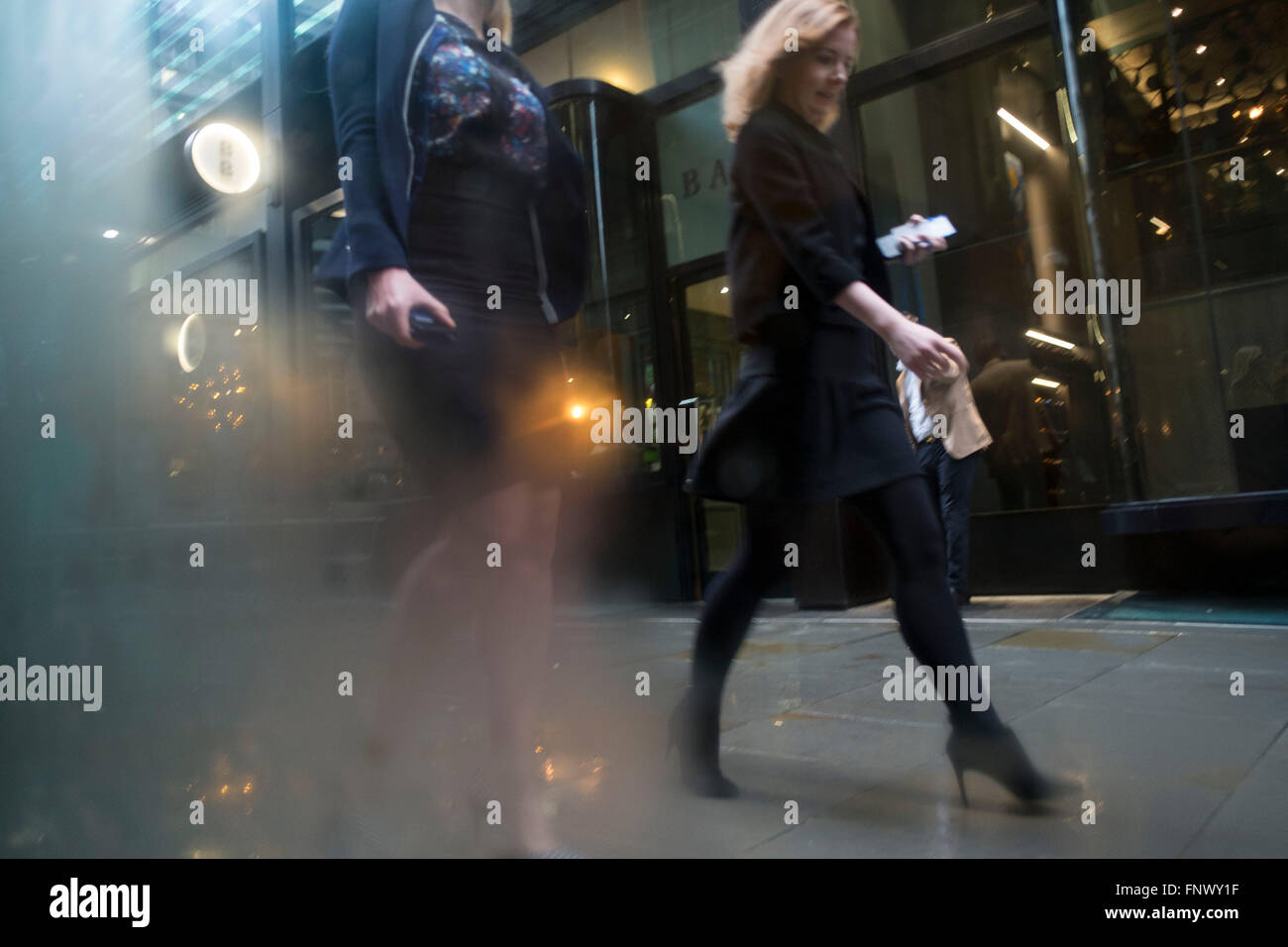 People out and about in the rain in the City of London, England, UK. January in the UK sees wet and cold weather, almost like a dreary scene from days gone by. Stock Photo