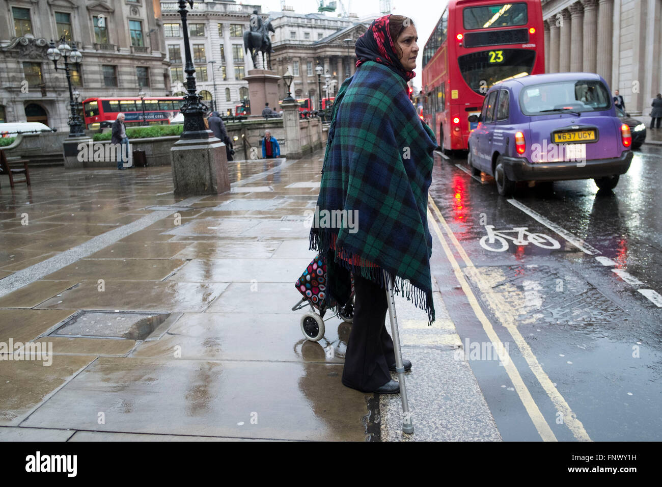 People out and about in the rain in the City of London, England, UK. January in the UK sees wet and cold weather, almost like a dreary scene from days gone by. Stock Photo