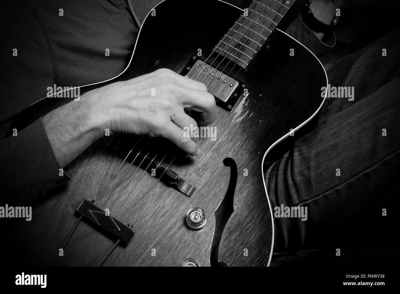 Practicing steel string guitar in informal setting- focus on right hand Stock Photo