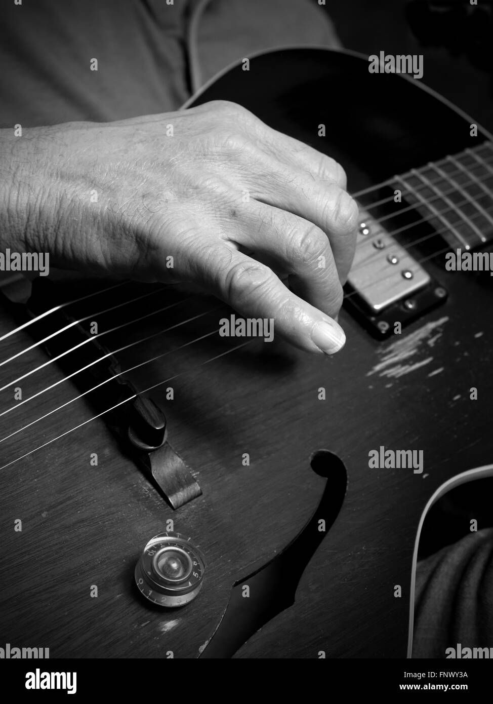 Practicing steel string guitar in informal setting- focus on right hand Stock Photo
