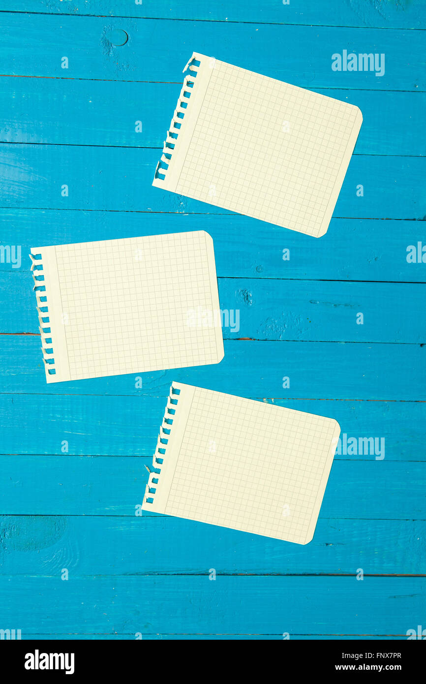 yellow sheet from a notebook on a blue wooden background Stock Photo