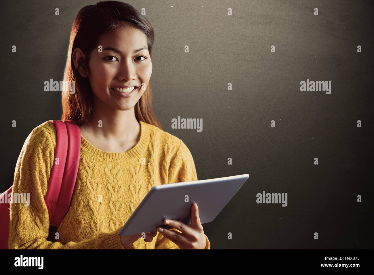 Composite image of smiling asian female student using tablet Stock Photo