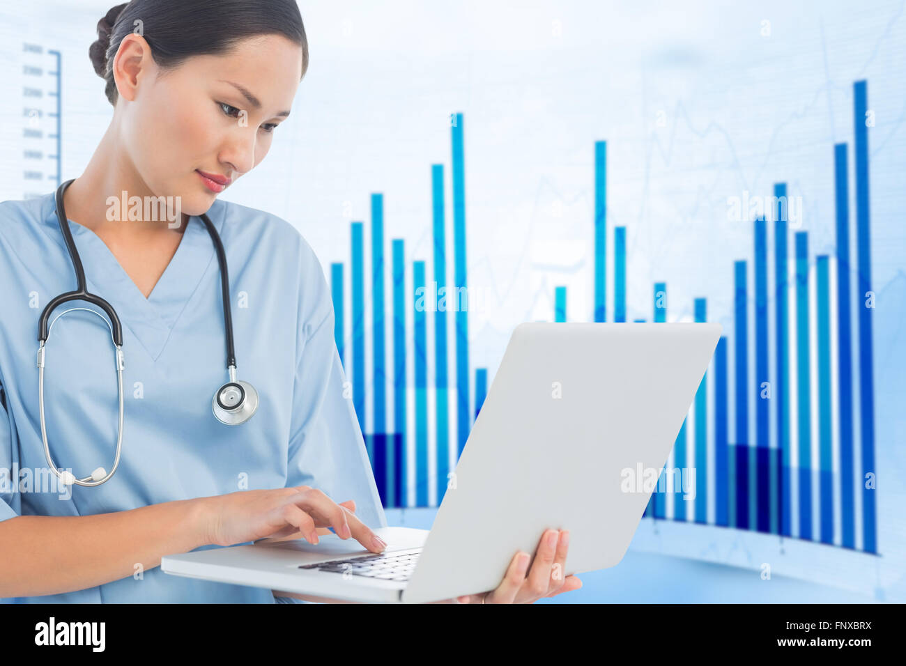 Composite image of concentrated surgeon using a laptop in hospital Stock Photo