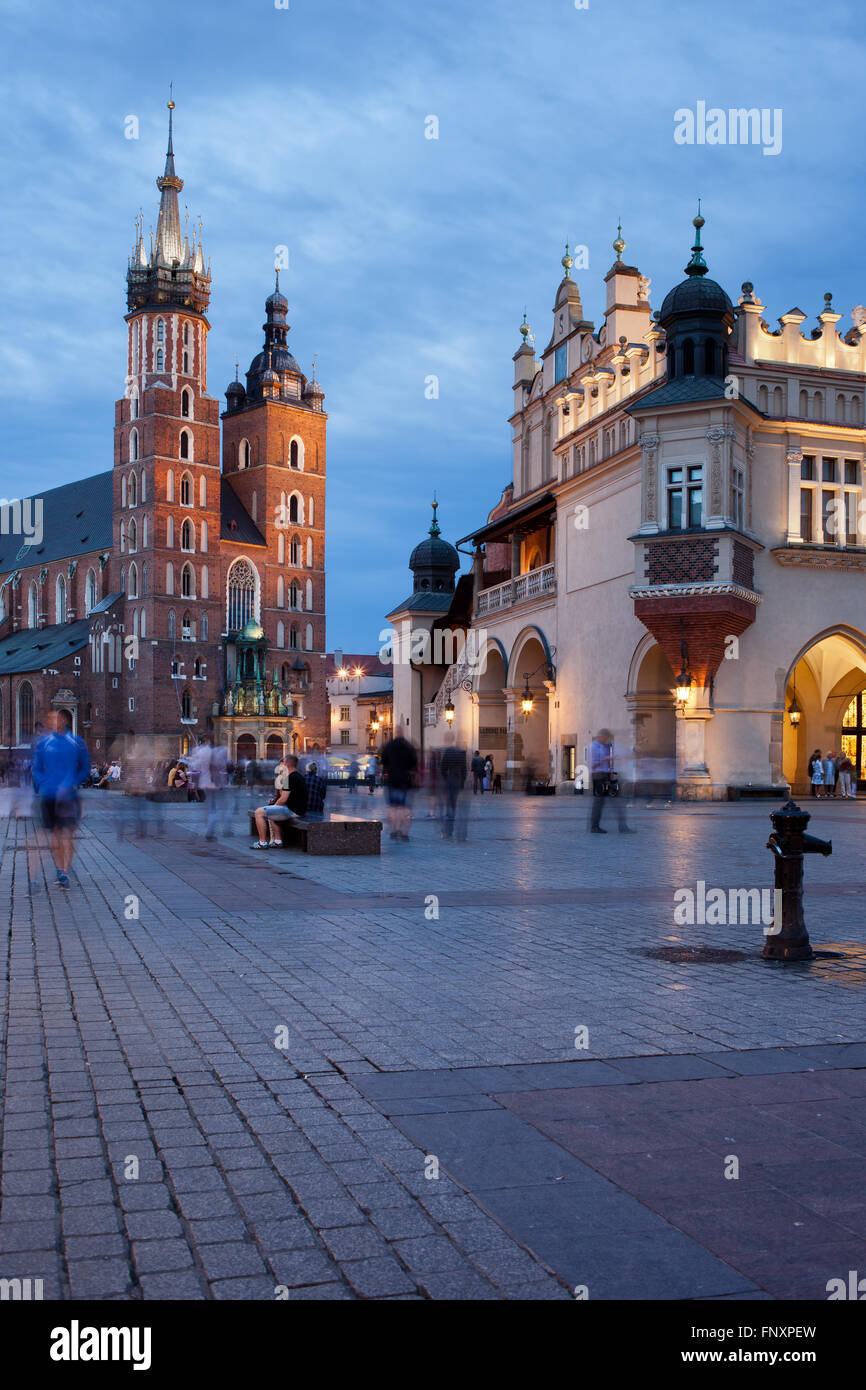 City of Krakow (Cracow) in Poland, Main Market Square at twilight in the Old Town, St. Mary Basilica and Cloth Hall - Sukiennice Stock Photo