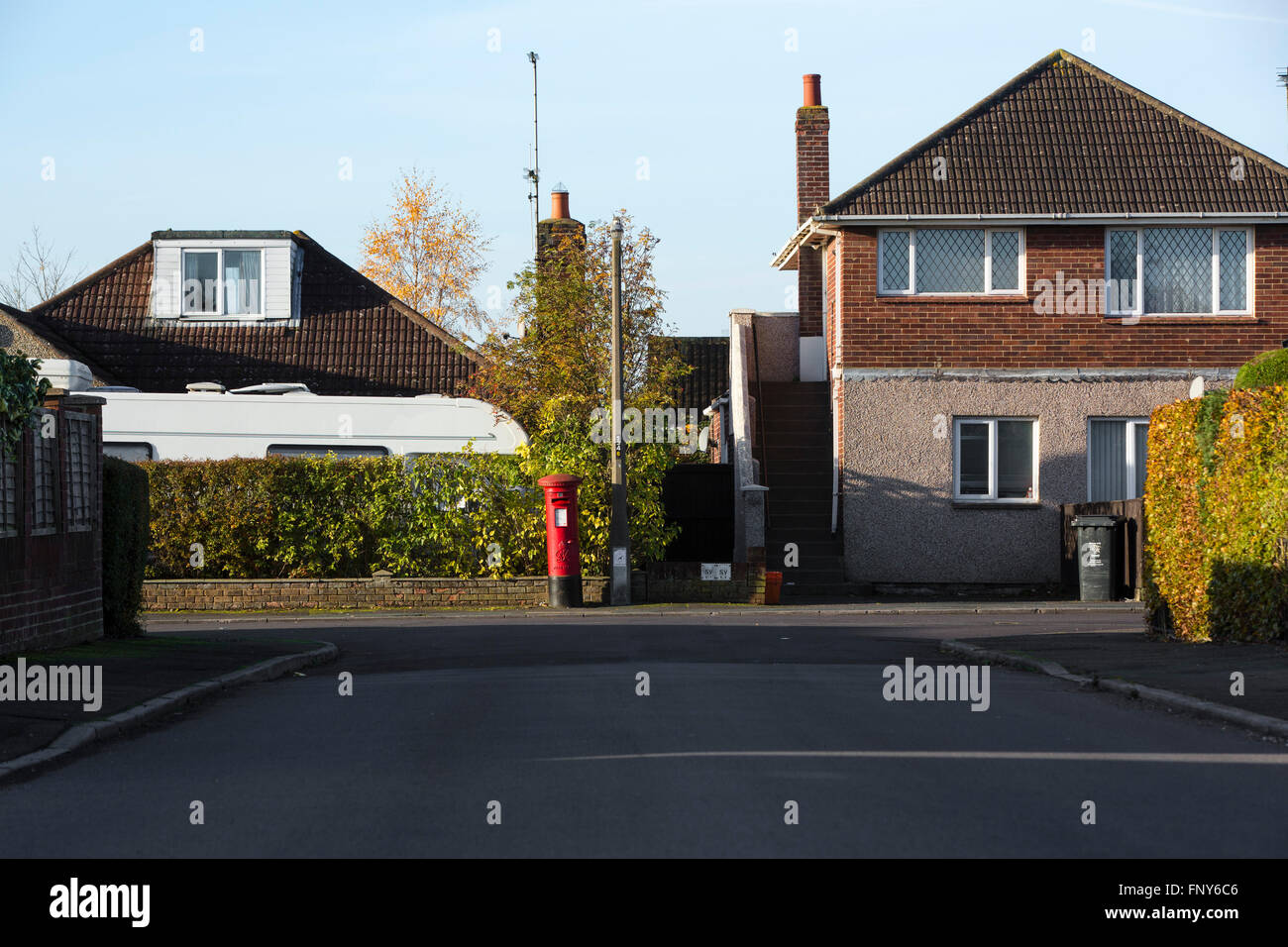 Street scene with hedge and red post box in Swindon, UK. Stock Photo