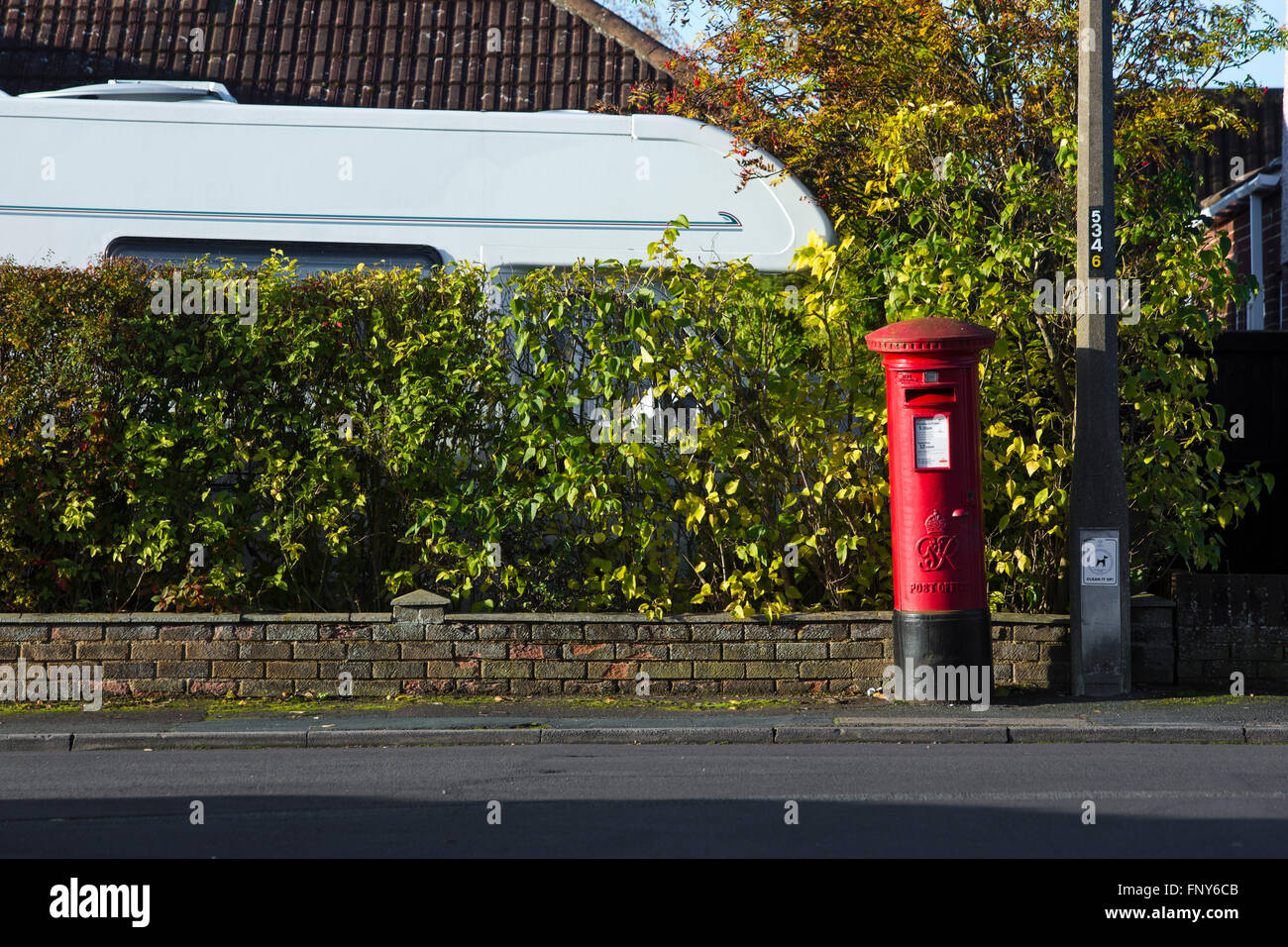 Street scene with hedge and red post box in Swindon, UK. Stock Photo