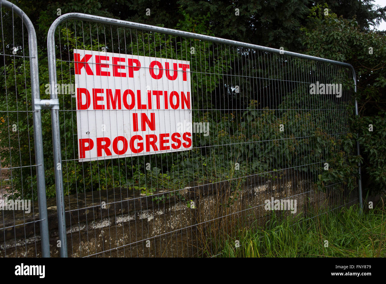 A red painted warning sign on a fence outside a demolition site Stock ...