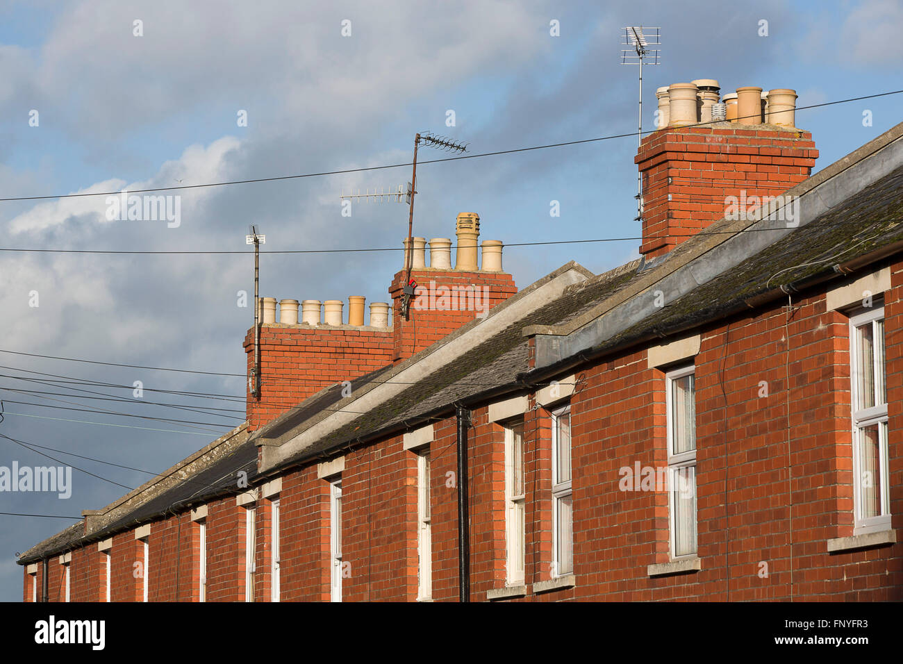 Red brick terraced houses with roof tops and chimmney tops. Stock Photo