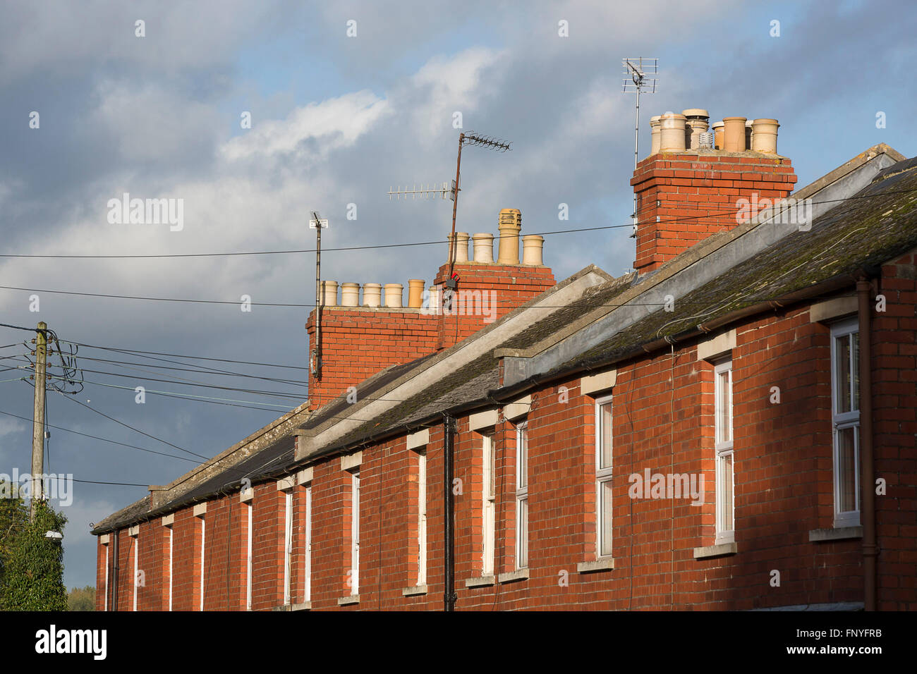 Red brick terraced houses with roof tops and chimmney tops. Stock Photo